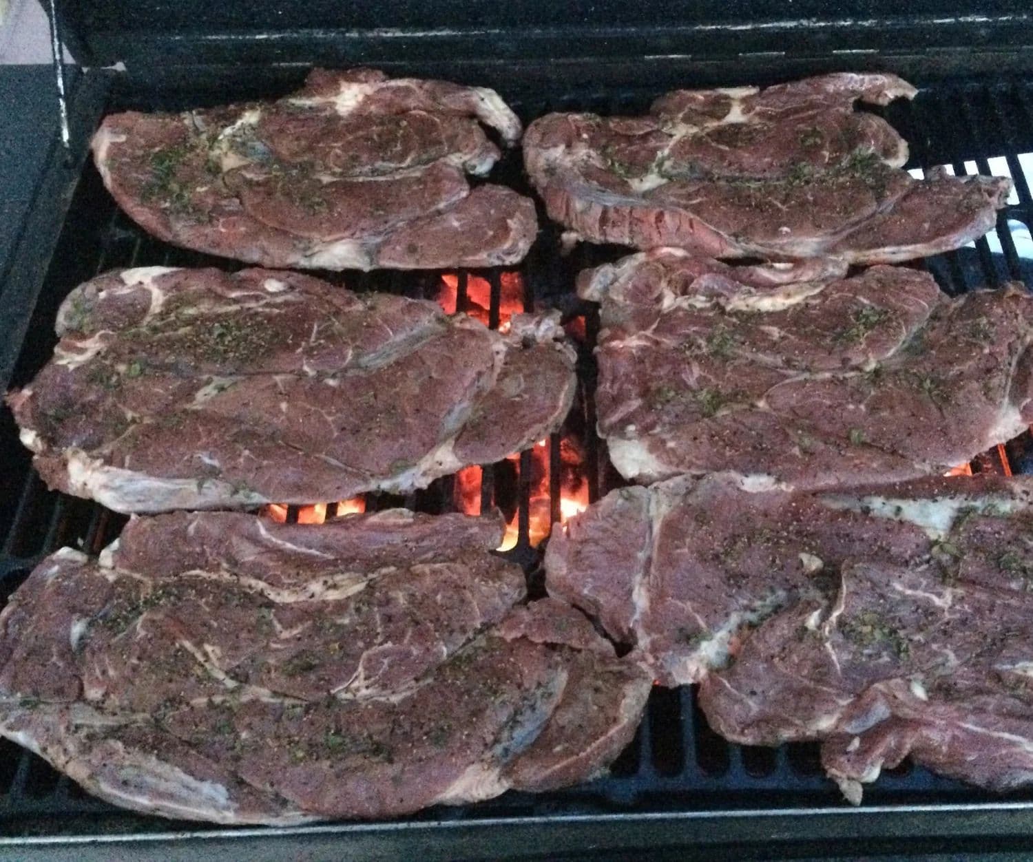 Carne asada sobre fuego de mezquite en un evento de Chicali Tacos